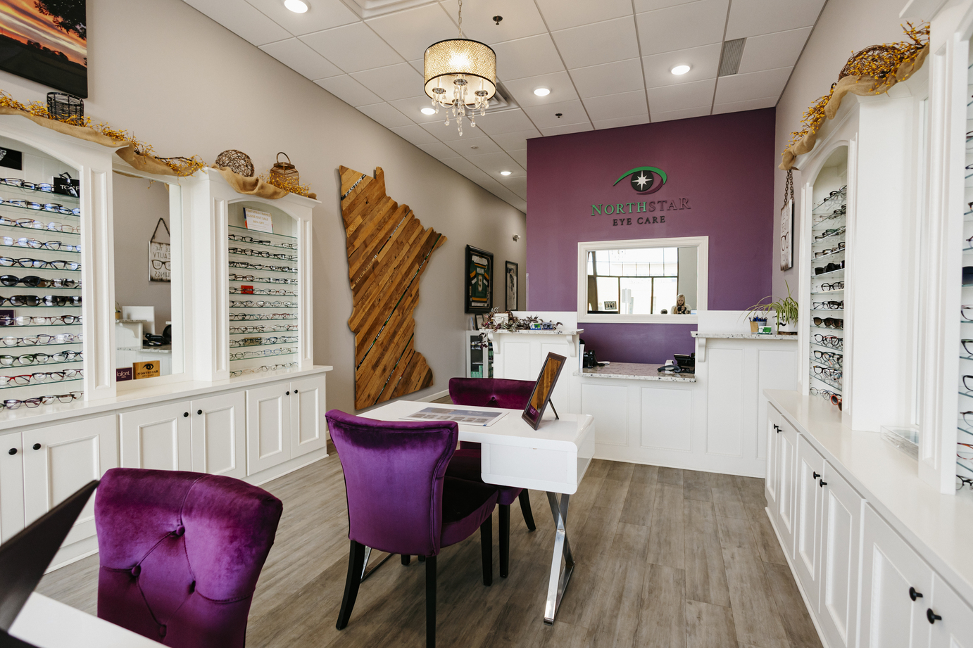 Reception area - North Star Eye Care Reception area featuring purple and wooden accents with white cabinets and glasses displays - North Star Eye Care